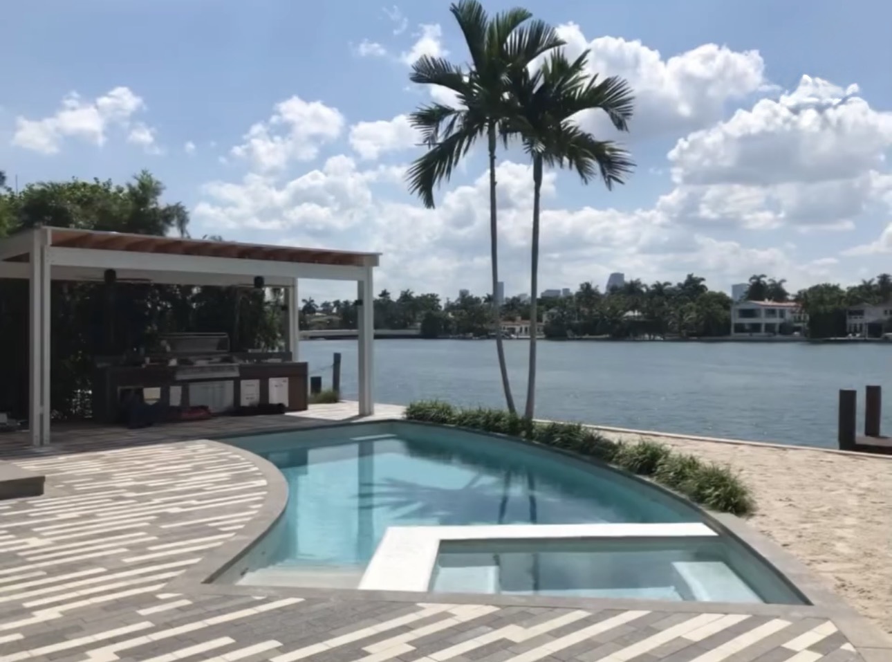 Waterfront pool with pergola and palms overlooking the bay