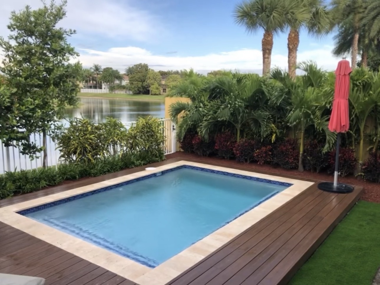Lakefront pool with wood deck and tropical landscaping