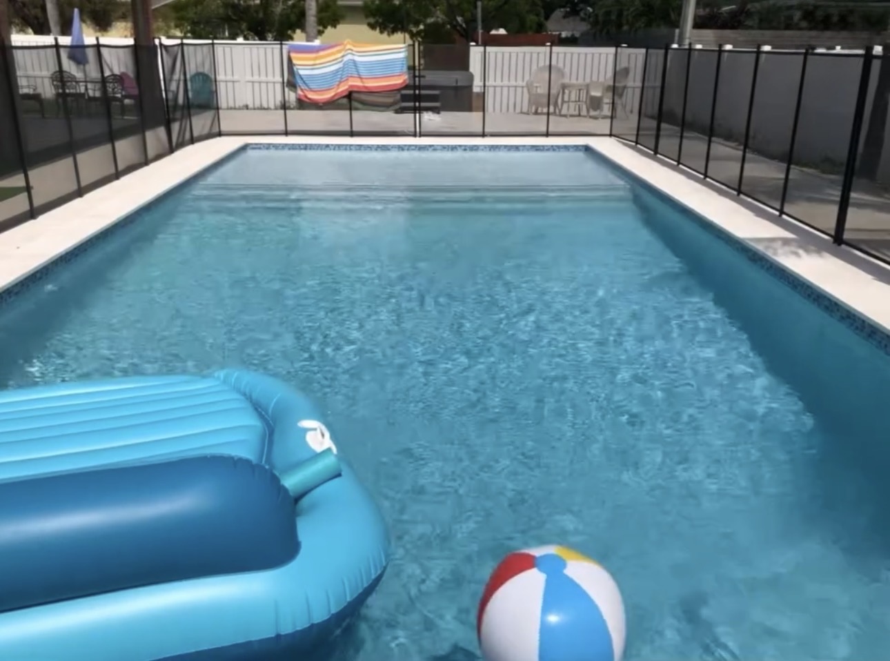 Backyard family pool with safety fence